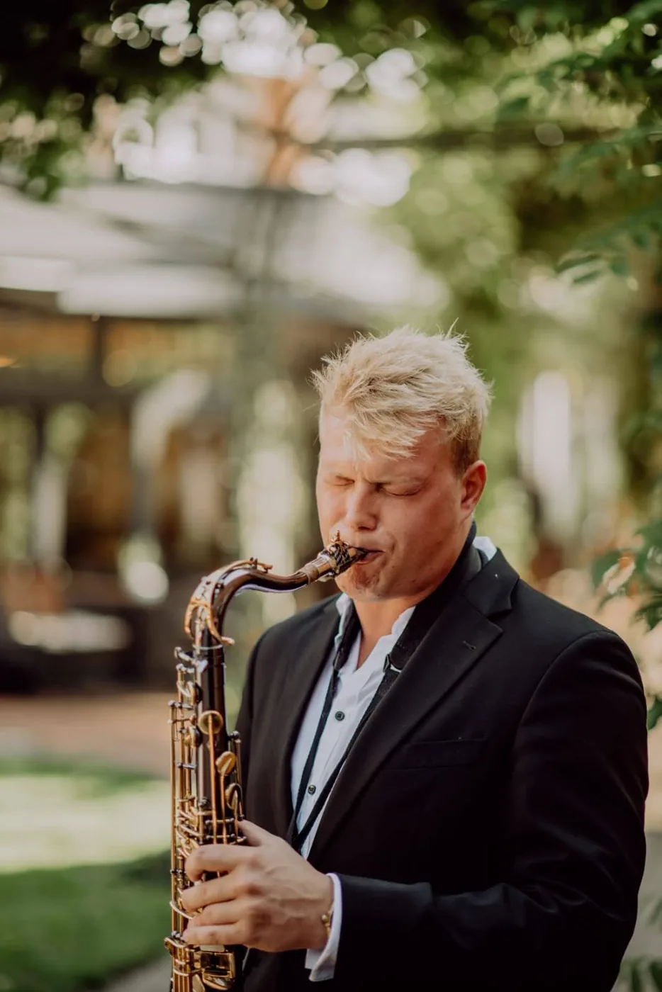 Felix Tönnies spielt Saxophon im Garten einer Eventlocation
