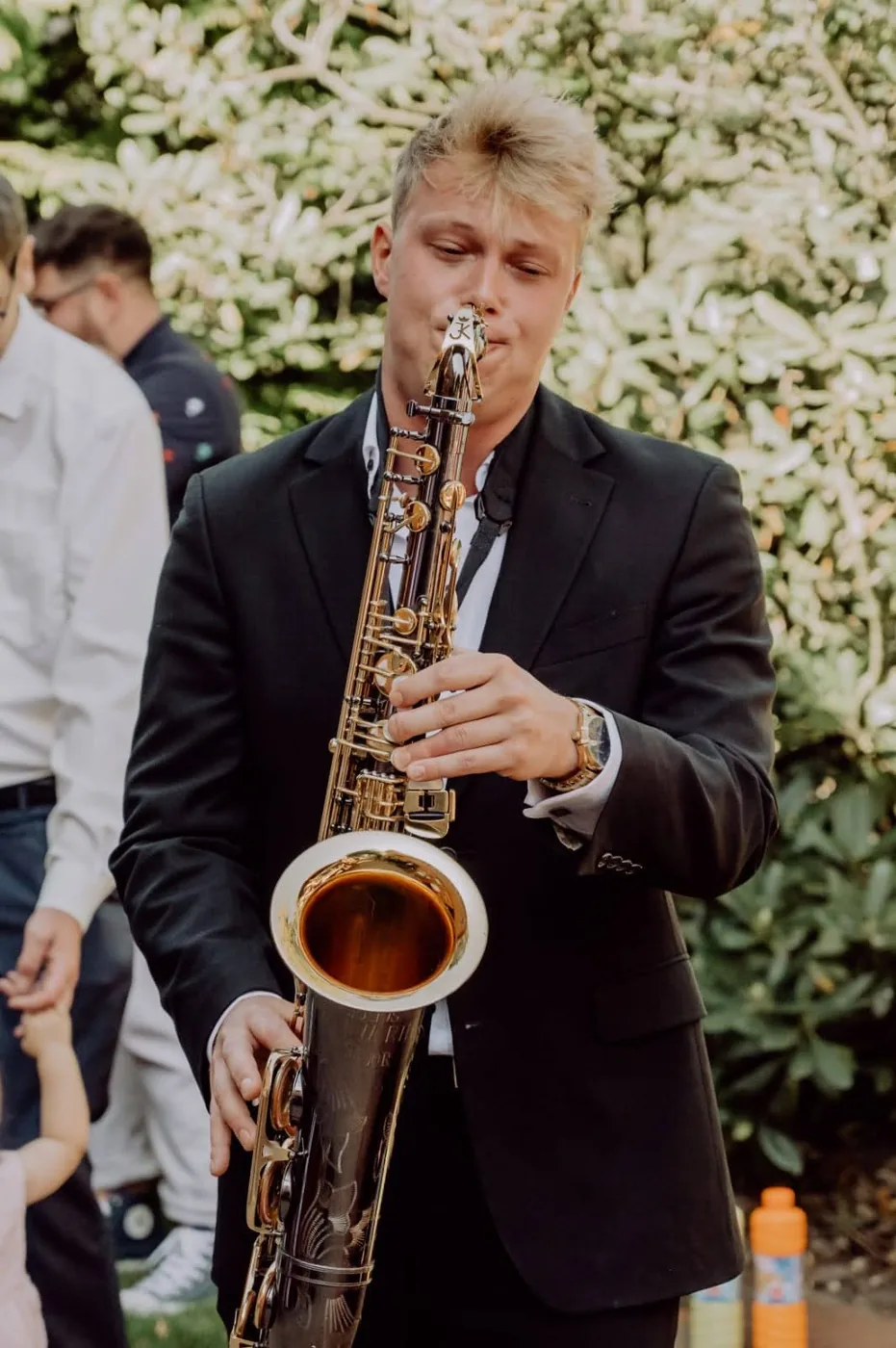 Felix Tönnies spielt Saxophon im Garten einer Hochzeitsfeier